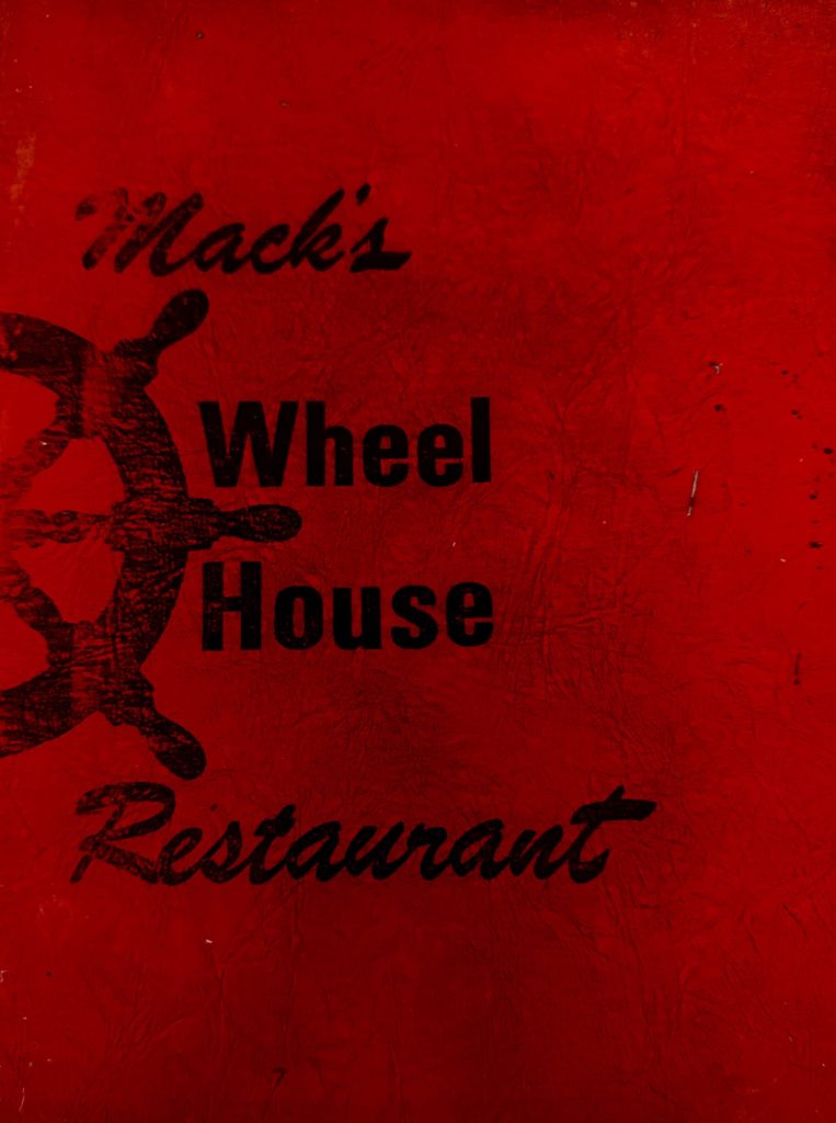 The original menu cover from Mack's Wheel House Restaurant, deep red with a ship's wheel and Mack's written in script